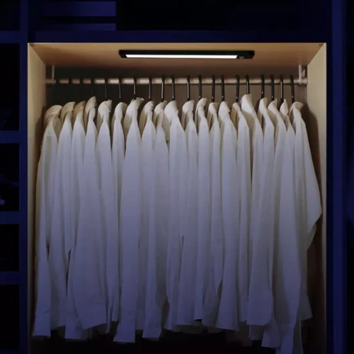 Motion sensor LED light bar lighting a wardrobe full of shirts